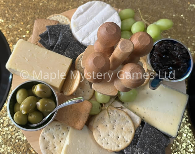 Cheesboard with pickles, olives, grapes and an assortment of crackers.