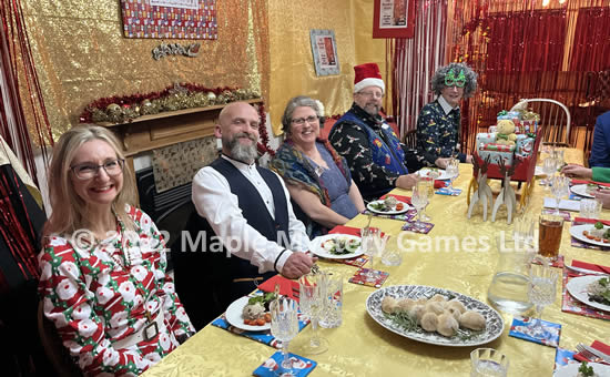Christmas-themed party - dinner table with sleigh and reindeer as a centerpiece; guests from left = Rosa, Major, Lady Ivy, Rafe and Noel