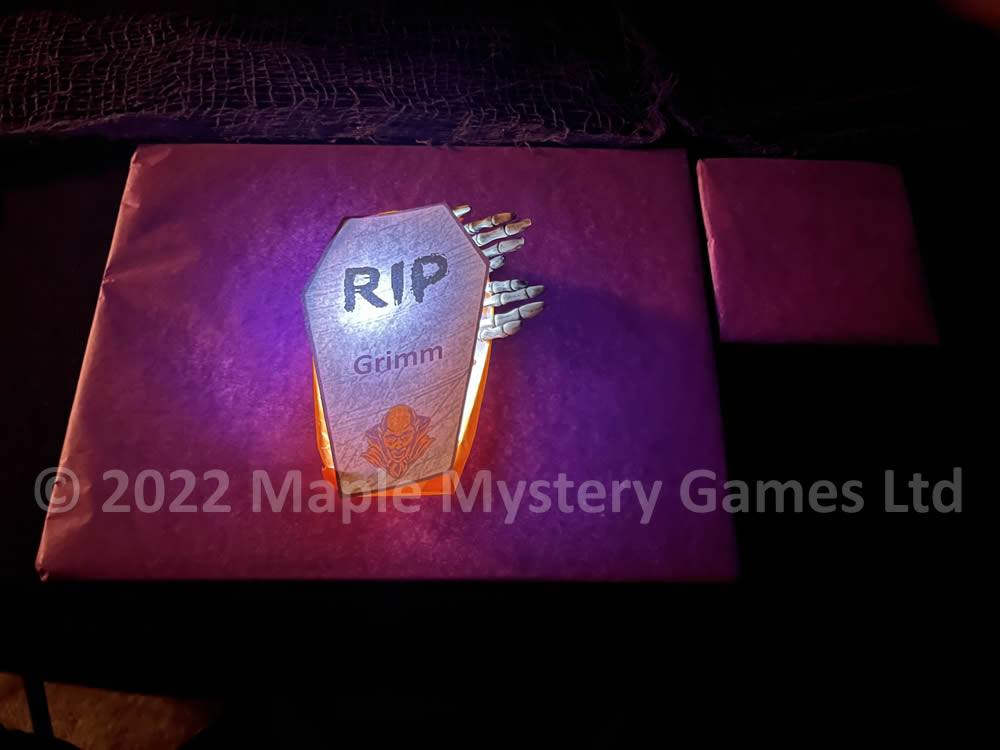 Coffin place setting has RIP and the player's name; orange coffin contrasts with a purple mat