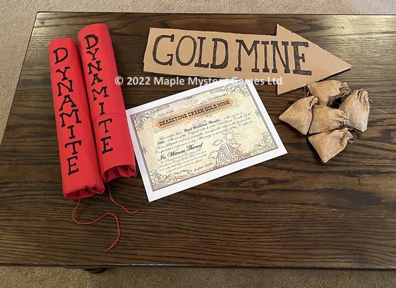 a gold mine scene created by two sticks of "dynamite", mini gold treasure bags, a cardboard arrow and a Deadstone Creek Gold Mine certificate