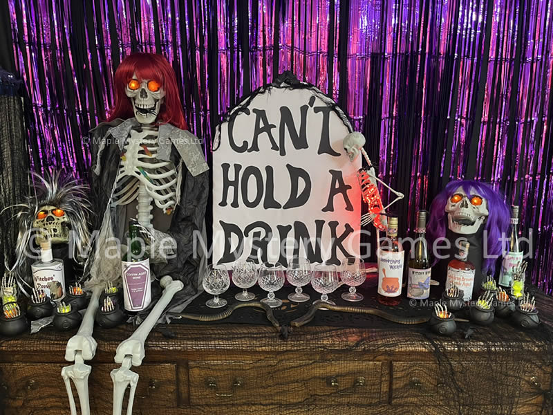 Halloween party decorations featuring cardboard gravestone, skeletons and skulls