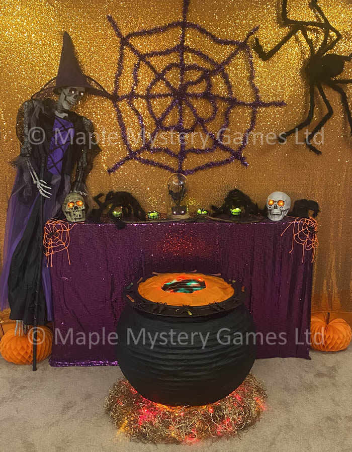 Halloween murder mystery party decorations feature large cauldron, skeletal witch and giant spider's web