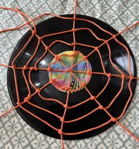 Making cobwebs using orange cord and a record guide