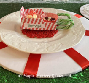 This Santa's sleigh place card is made out of a single sheet of paper and decorated in a candy cane style.