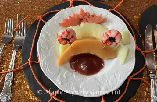 Melon trio, lychees and raspberry coulis presented in a spooky way as a monster face